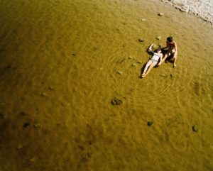 13. Madre E Figlia - Steven Nestor - "A mother and daughter enjoying personal time out together, away from the crowded beach. Sardegna, 2018. I took this image while waiting for friends to follow me home. The heatwave was suffocating and the beach crowded, but in the fresher waters of a river below me I watched a mother and daughter enjoying their time together in silence. It was as though no other time pressures or constraints could hope to interrupt their time. My friends arrived and I merged with them. It was we who were time conscious, too aware of the day's prearranged necessities.
